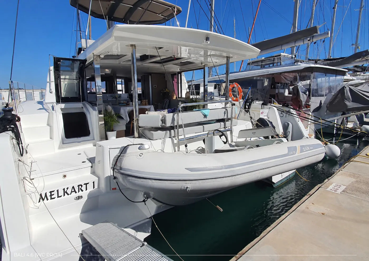 Melkart I moored stern-to with her tender, name visible on the hull